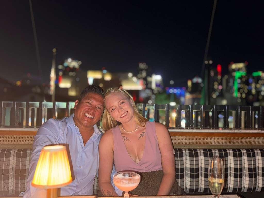 Hanne Engan seated with her husband at night in front of a city skyline