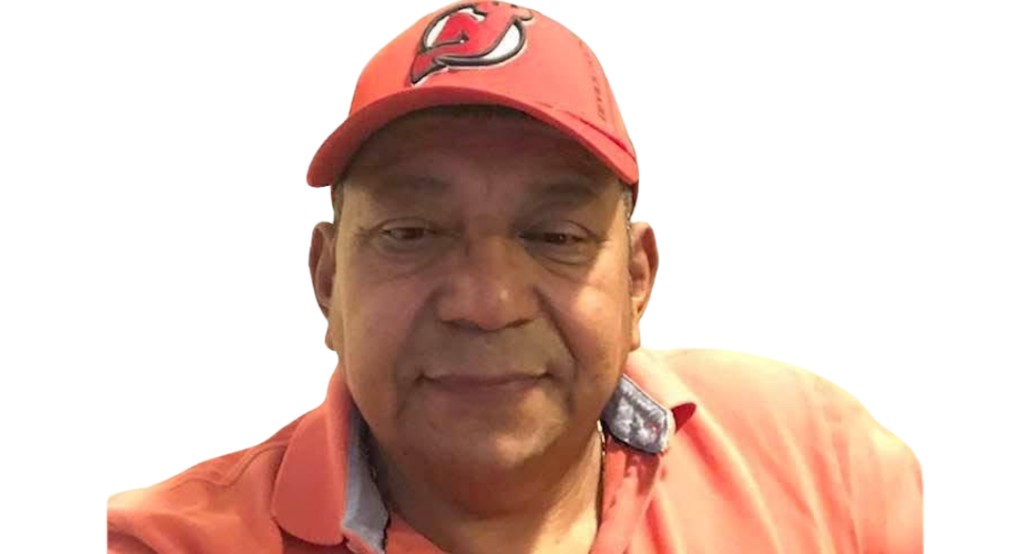 Luis Beltrán Yánez Cruz wearing a red New Jersey Devils cap and a salmon polo shirt