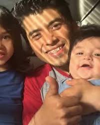 Martin Soto smiling with two young children, giving a thumbs-up