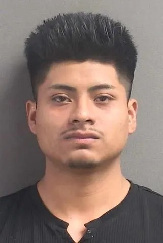 Royer Perez-Jimenez in a booking-style portrait wearing a black shirt